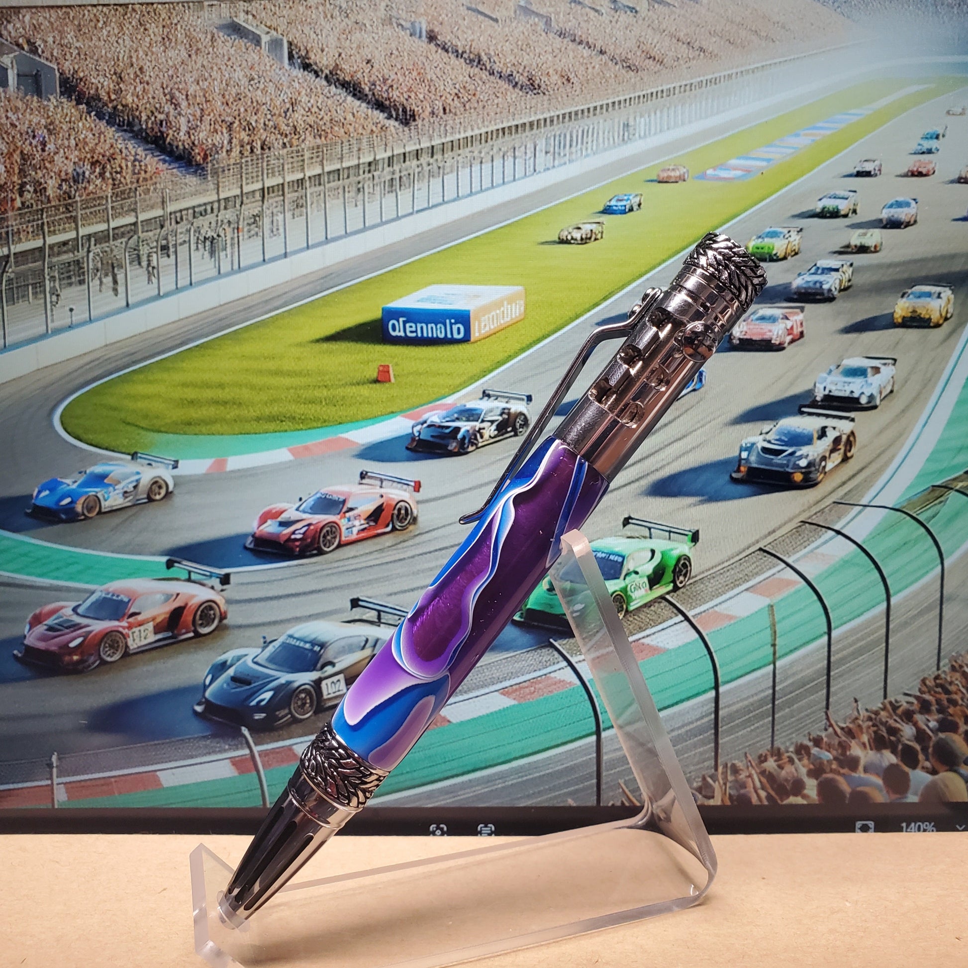 Colorful pen with flame design on a stand in front of a race track background